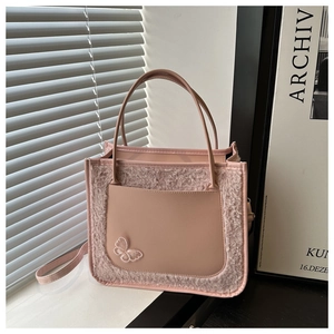 Detail of pink PU leather tote with faux fur panel and butterfly embroidery detail