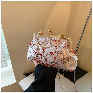 Detail of vintage Chinese embroidery bag with red plum blossoms and gold metal hardware