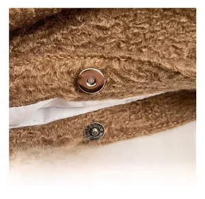 Détail du fermoir magnétique argenté sur sac en peluche marron avec couture fine