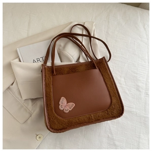 Detail of winter brown faux fur tote bag with leather pocket and pink butterfly embroidery