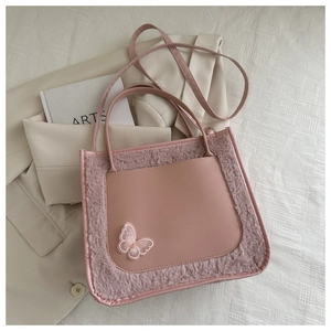 Pink faux fur PU leather tote bag with butterfly embroidery on beige suit and arts book