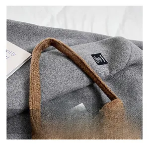 Détail d'un sac cabas marron en peluche montrant la texture douce et l'anse confortable