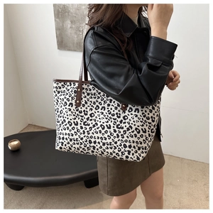 Detail of leopard print tote bag with brown PU leather handles and metal rivets