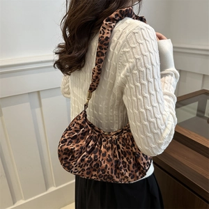 Close-up of leopard print hobo bag with pleated texture and golden metal buckle