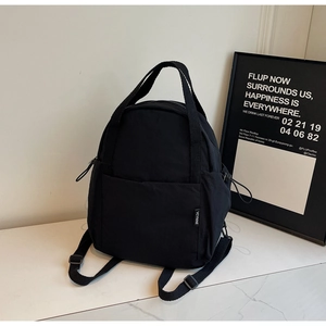 Détail du sac à dos minimaliste YCYNINE en nylon noir avec étiquette de marque et cordon