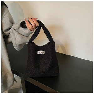 Détail du sac à main en maille peluche noire avec étiquette LOVE FASHION pour l'hiver