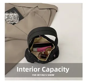 Intérieur spacieux du sac matelassé noir montrant téléphone et étui de maquillage