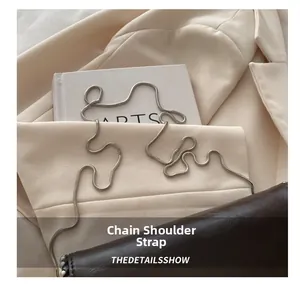 Detailed close-up of a dark brown leather bag with high-quality silver snake chain strap
