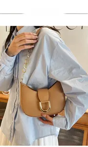 Detail of khaki crescent shoulder bag with golden D-buckle and chain strap on model