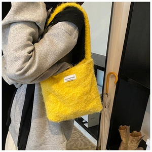 Gros plan d'un sac cabas jaune en fausse fourrure montrant la texture pelucheuse