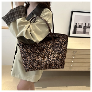 Detailed side view of a large leopard print tote bag styled with a khaki trench coat