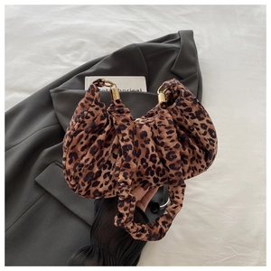 Detail view of the leopard print fabric and pleated handle with gold hardware accents