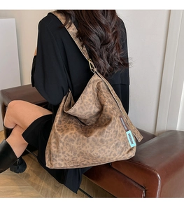 Detailed side view of the spacious leopard print tote bag with stylish brand tags
