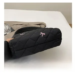 Détail du fond matelassé résistant à l'usure et des coutures soignées du sac cabas noir