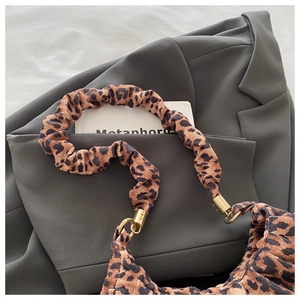 Macro shot of leopard print corduroy bag with stylish pleats and gold metal rings