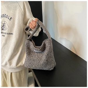 Détail du sac à main en peluche grise avec texture laine et étiquette mode