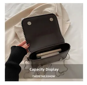 Macro view of small brown crossbody bag capacity showing space for a smartphone