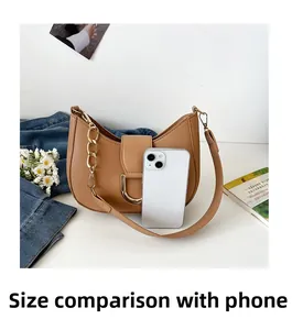 Detailed size comparison of tan hobo bag with smartphone and golden chain strap