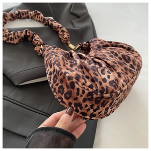 Close-up of leopard print baguette bag with pleated texture and stylish shoulder strap