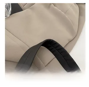 Gros plan des poignées noires sur un sac cabas beige rembourré pour femme