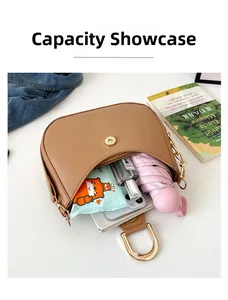 Top view showing interior capacity of tan crescent bag with phone, umbrella, and perfume