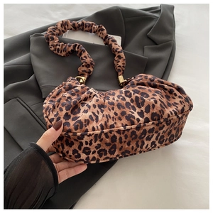 Close-up of leopard print shoulder bag with ruched details and gold hardware rings