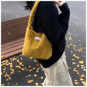 Détail du sac à bandoulière en peluche gingembre avec fil plume et étiquette de logo