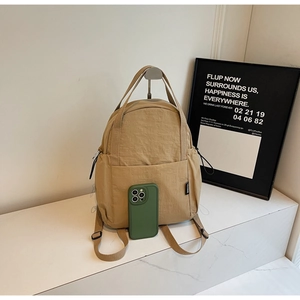 Vue détaillée du mini sac à dos kaki avec smartphone montrant sa taille compacte