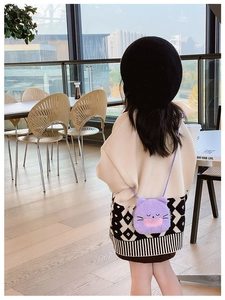 Detail of cute purple plush cat crossbody bag with cartoon face and thin shoulder strap