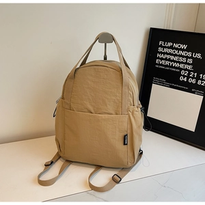 Vue détaillée du sac à dos en nylon kaki avec poches latérales et étiquette de la marque
