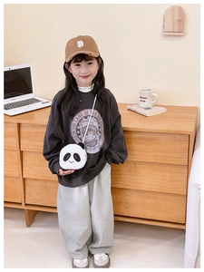 Plush panda cross-body bag paired with a gray sweatshirt and wide-leg pants