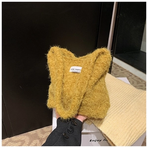 Détail du sac à main en peluche jaune gingembre avec texture douce et étiquette de mode