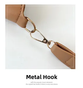 Close-up of golden metal lobster clasp and premium brown leather strap with stitching detail