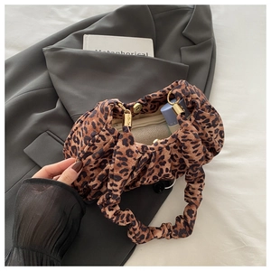 Detail view of the leopard print bag showing the ruched handle and magnetic gold clasp closure