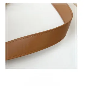 Close-up of brown leather shoulder strap showing fine stitching and natural texture