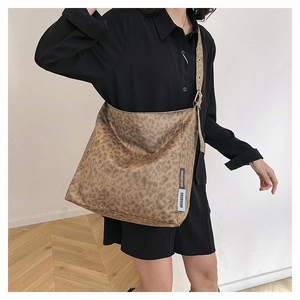 Detail of vintage leopard print tote bag featuring custom brand labels and fabric texture