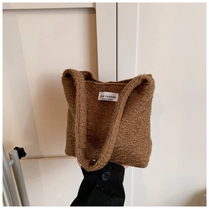 Gros plan du sac cabas en peluche marron avec texture polaire douce et étiquette blanche