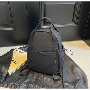 Détail d'un sac à dos en nylon noir avec étiquette YCYNINE et cordon de serrage latéral