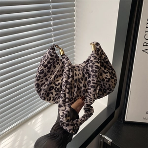 Detail of leopard print fabric bag showing high-quality pleats and gold metal rings