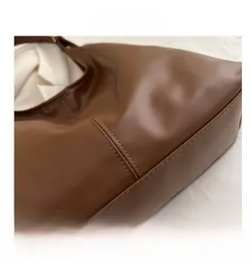 Detailed close-up of brown PU leather texture and precise stitching on the tote bag