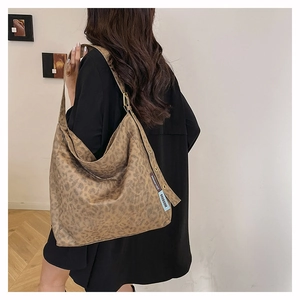 Detail view of large leopard print tote bag with metallic eyelet side strap detail