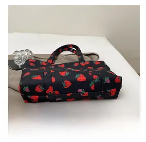 Detail view of strawberry print tote bag showing durable wear-resistant bottom design