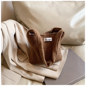 Détail de la texture pelucheuse marron et de l'étiquette tissée sur un sac à main d'hiver