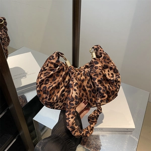 Detail of leopard print cloud bag with soft pleated texture and gold hardware accents