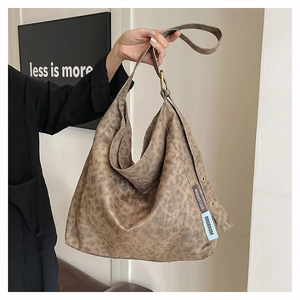 Detail of vintage leopard print tote bag featuring metallic buckle and textured finish