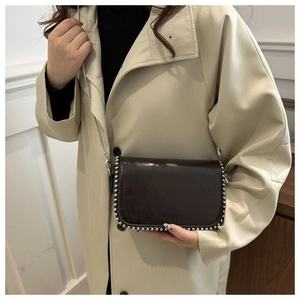 Close-up of vintage dark brown crossbody bag with silver beaded trim and chain strap