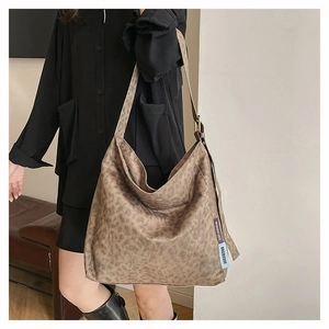 Detailed view of large vintage leopard print tote bag texture and branded side labels