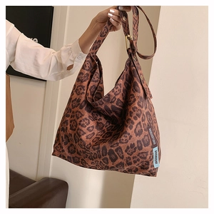 Detail shot of vintage leopard print canvas tote with adjustable strap and branding tag