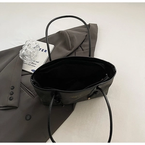 Interior view of large black leather tote bag with spacious compartment and zipper pocket
