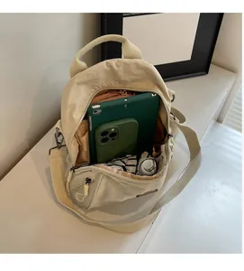 Spacious interior of beige nylon backpack showing functional pockets and large storage space